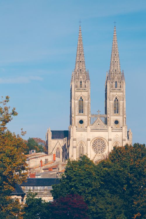 Free Stunning view of St Andrews Church in Niort, France surrounded by lush trees. Stock Photo