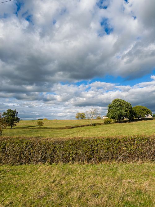 Free Idyllic rural landscape with lush greenery and cloudy sky in Malmesbury, England. Stock Photo