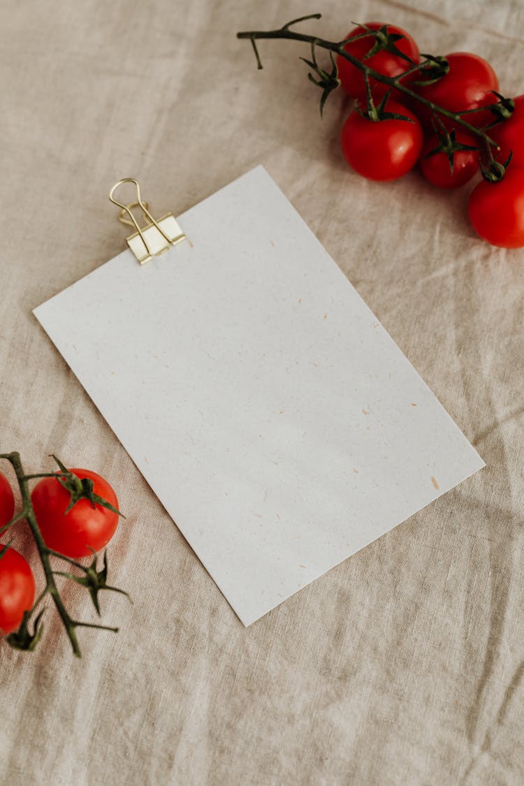 Fresh Tomatoes And Empty Clipboard On Kitchen Table