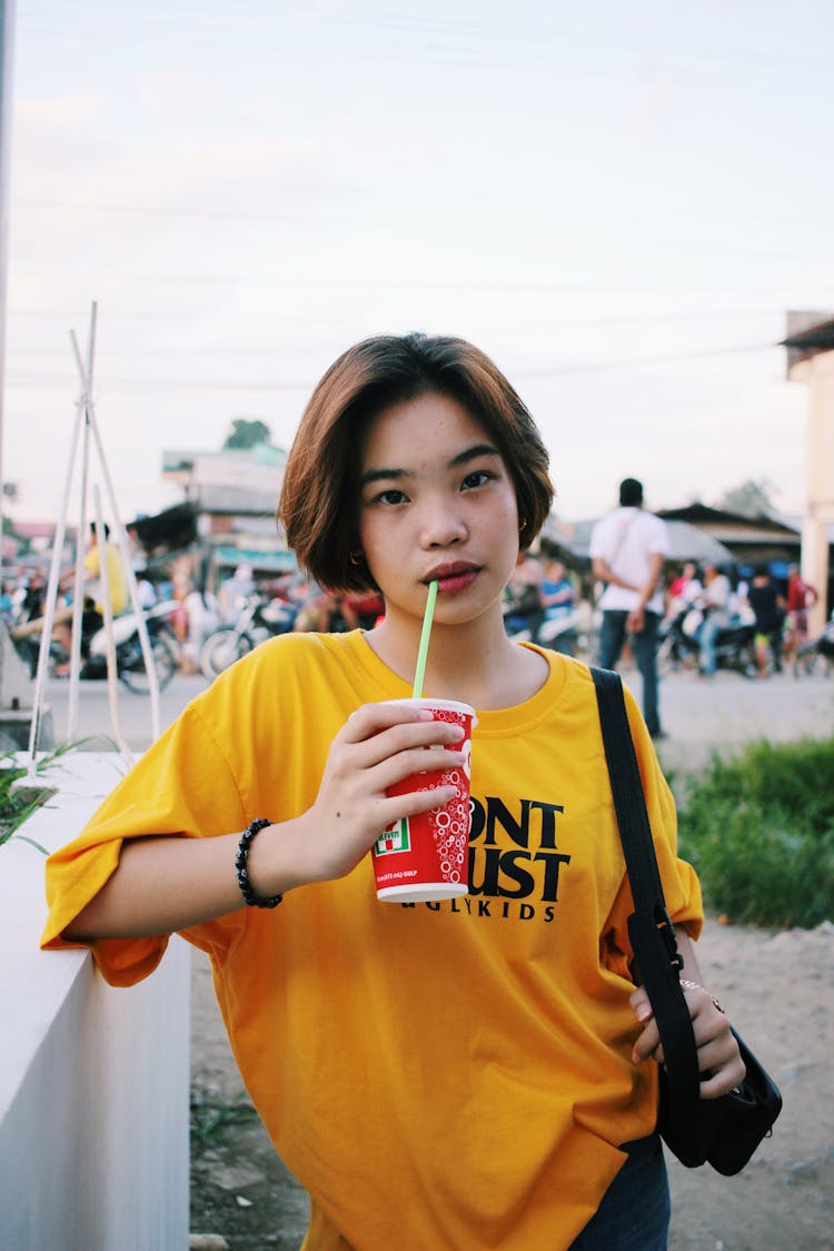 Trendy Ethnic Young Lady Drinking Soda With Straw On Street