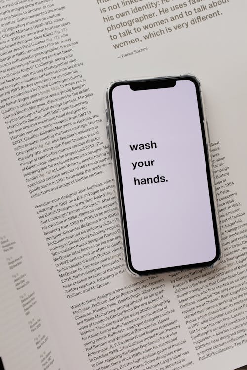 Free Opened book with smartphone with warning message Stock Photo
