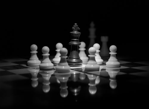 Free A compelling black and white chess scene with a queen surrounded by pawns, symbolizing strategy. Stock Photo