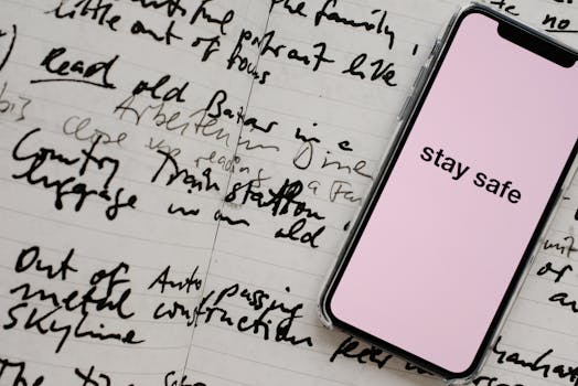 Smartphone displaying 'stay safe' on a notepad surrounded by handwriting. Perfect for messaging themes.