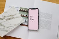 Smartphone screen with STAY AT HOME inscription and open magazine