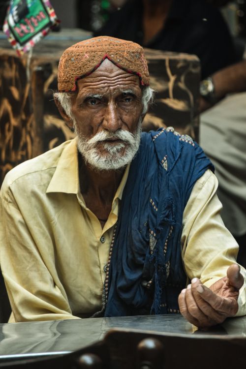 Free Elderly man wearing traditional Sindhi attire, seated indoors, Hyderabad, Pakistan. Stock Photo