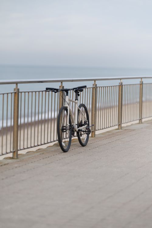 Free A bicycle rests against a railing along the beach in Lesnoe, Kaliningrad Oblast, Russia on a peaceful day. Stock Photo