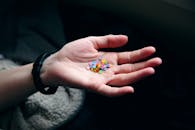 在黑暗背景下，一只手握着五颜六色的五彩纸屑，展现出充满活力的色彩