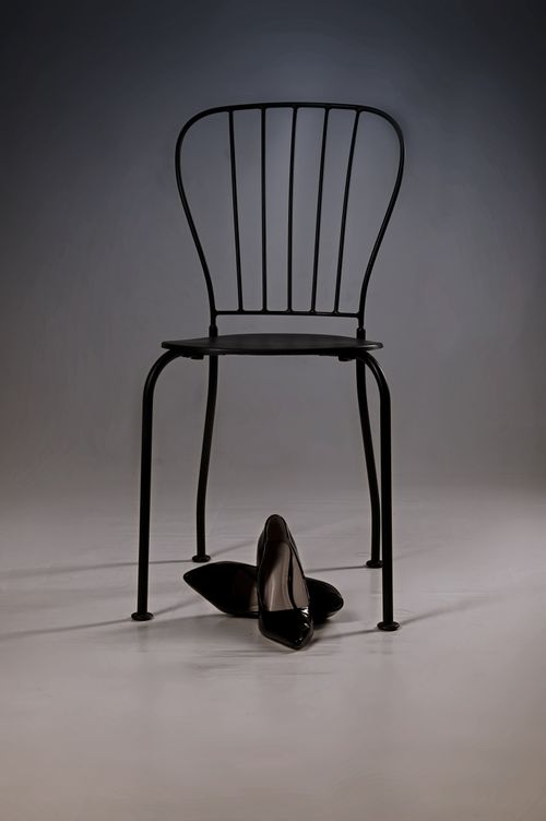 Free Simple yet elegant composition of a black chair with high heels on a neutral background. Stock Photo
