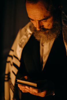 一个穿着传统犹太服装、留着大胡子的男人，拿着一本书，陷入沉思