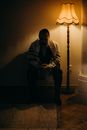 Bearded Man Sitting Next to a Lamp