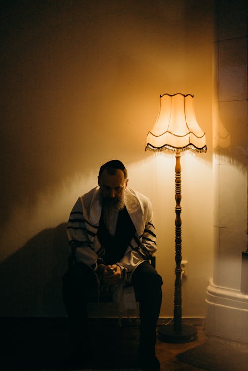 Bearded Man Sitting Next to a Lamp