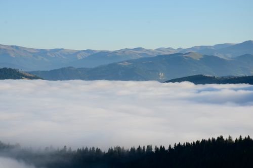 Free Beautiful mountain range covered in mist with a clear blue sky in the background. Serene and tranquil landscape view. Stock Photo