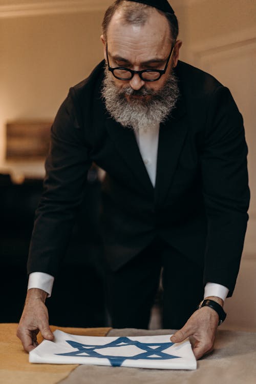 Bearded Man Folding the Flag of Israel