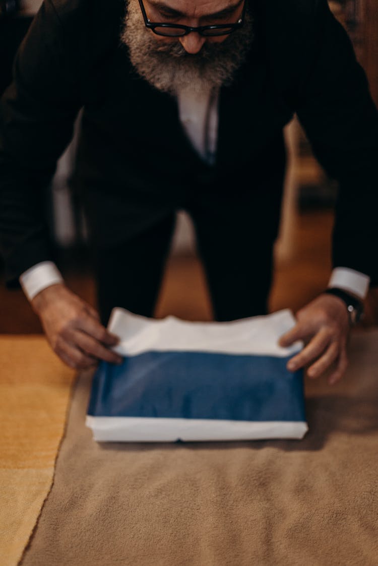 Bearded Man Folding A Flag