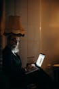 Dimly Lit Room: Man Focused on Laptop Work