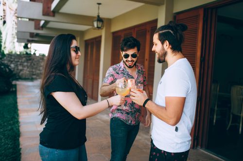 Free A group of friends enjoying a cheerful moment with drinks outdoors, embodying friendship and togetherness. Stock Photo