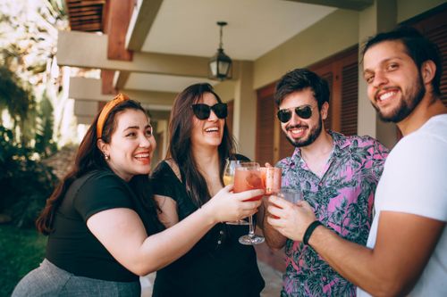 Free Group of friends smiling and toasting drinks outside. Perfect for lifestyle and celebration themes. Stock Photo