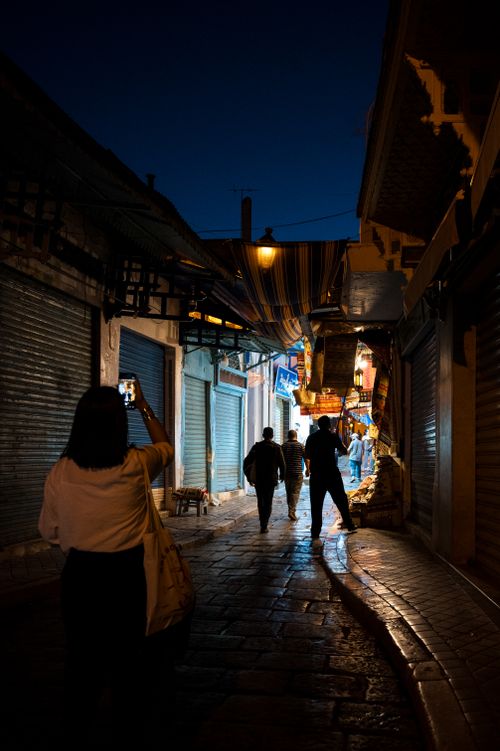 Free Evening scene capturing people walking through the vibrant Medina of Tunis. Stock Photo