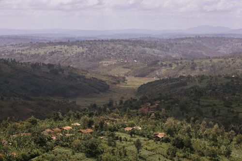 Free Aerial view of lush green hills and valleys in the African countryside under a cloudy sky. Stock Photo