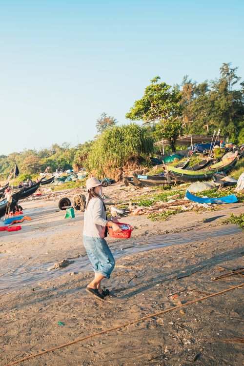 Free Vibrant scene at Cửa Tùng beach with a local fisherman carrying a basket. Ideal for travel and lifestyle imagery. Stock Photo