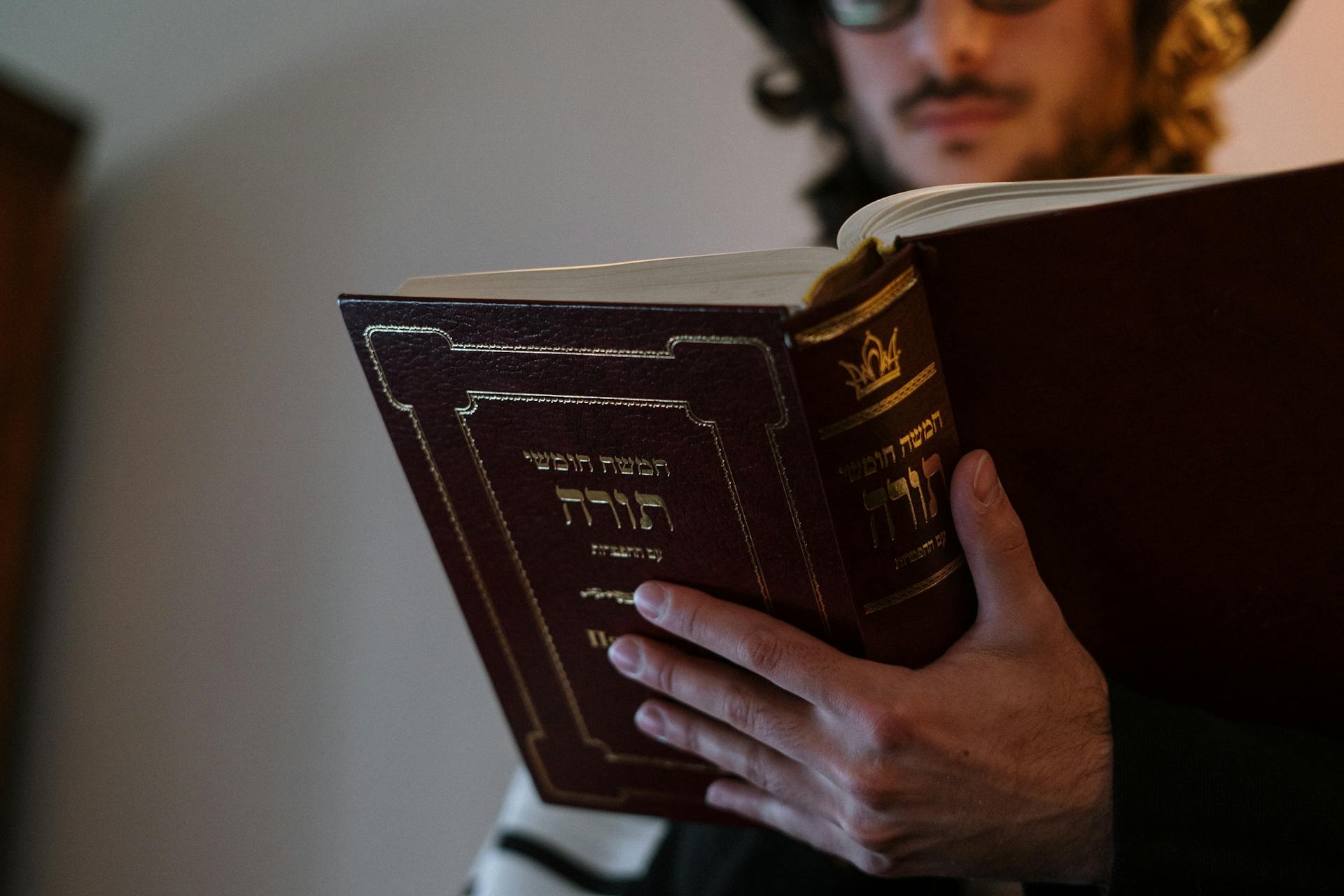 Young Man Reading a Book in Hebrew