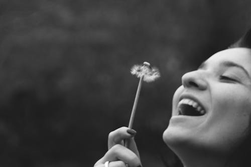 Smiling Woman Holding Dandelion Flower