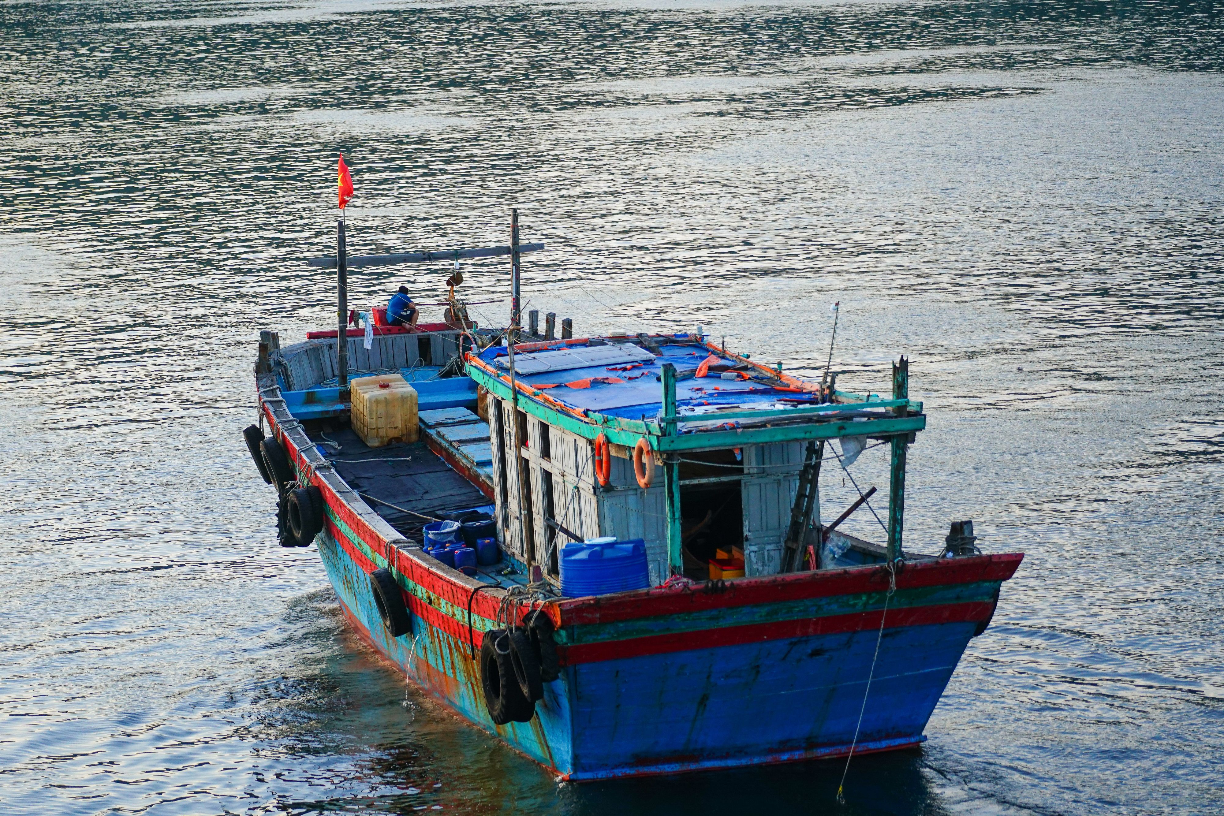 Colorful fishing boat floating on the serene waters of Da Nang, Vietnam, captures a peaceful maritime scene.