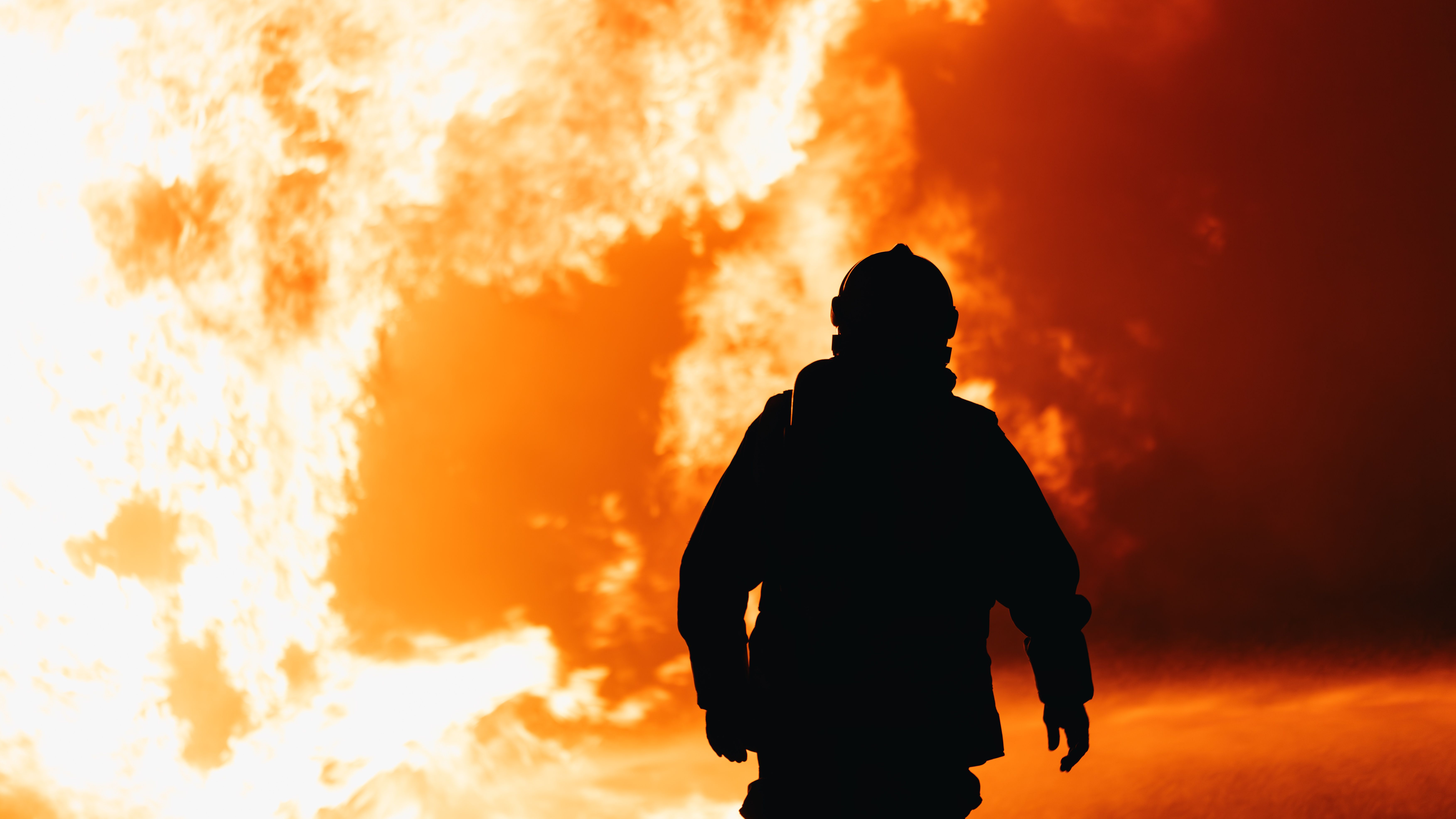 Firefighter Silhouette Against Intense Blaze · Free Stock Photo