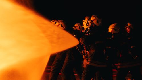 Free A group of firefighters in protective gear tackle flames during a nighttime operation. Stock Photo