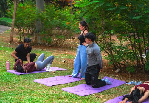 Free A group practicing yoga in a lush Jakarta park, promoting well-being and mindfulness. Stock Photo