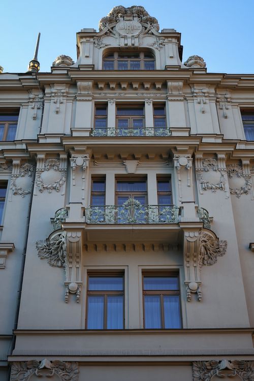 Free Beautifully decorated facade of a European building featuring intricate balconies under clear skies. Stock Photo