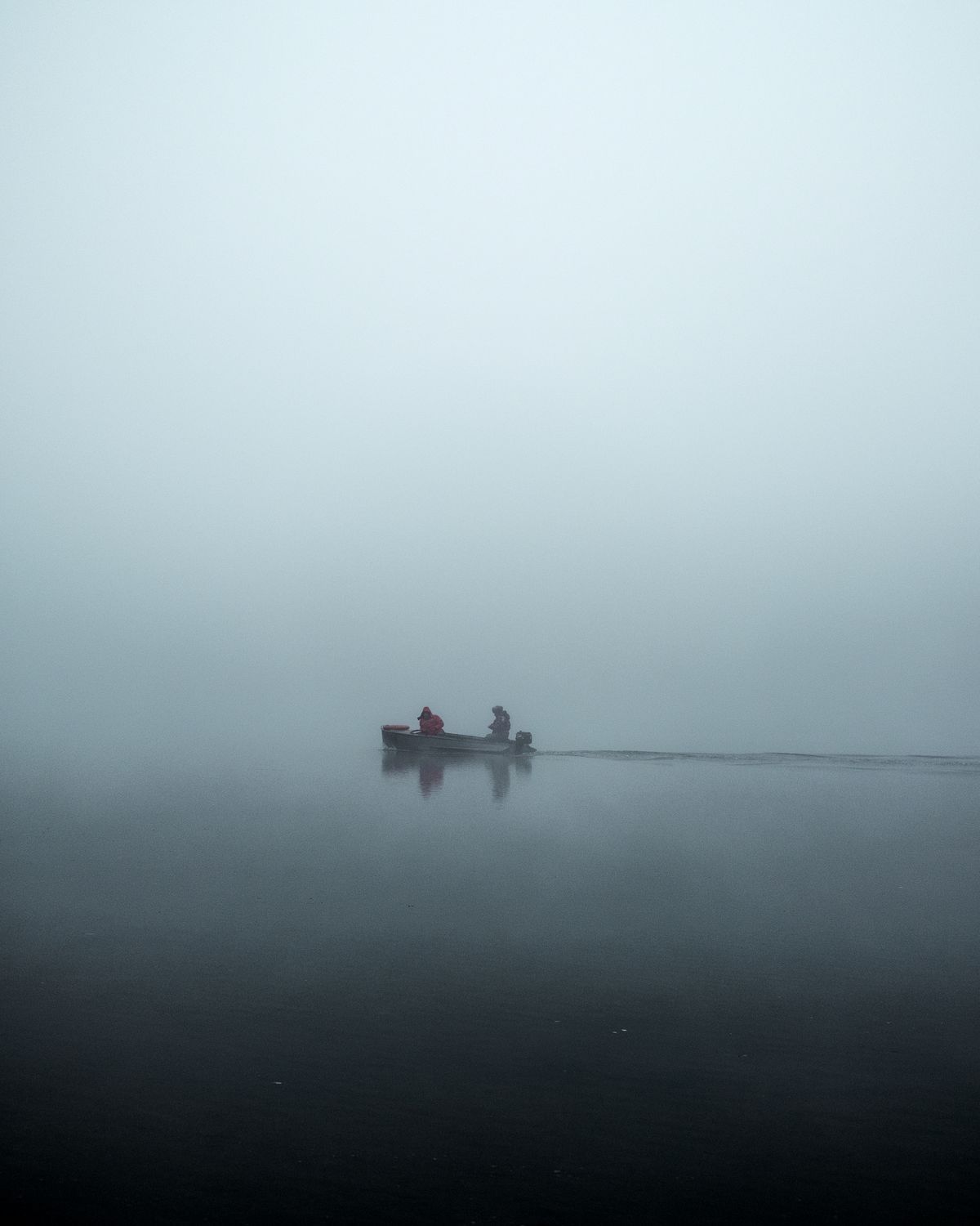 A calm river winding through boreal forest in northern Sweden, the water clear and still in morning light
