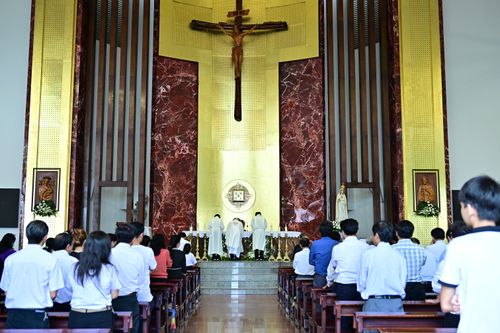 Free A congregation gathers in a church, observing a religious ceremony at the altar. Stock Photo