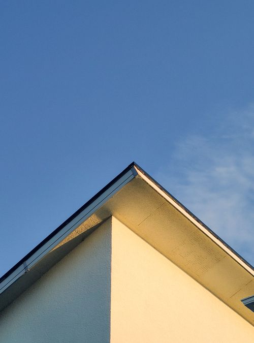 Free A simple and modern building roof set against a clear blue sky. Stock Photo
