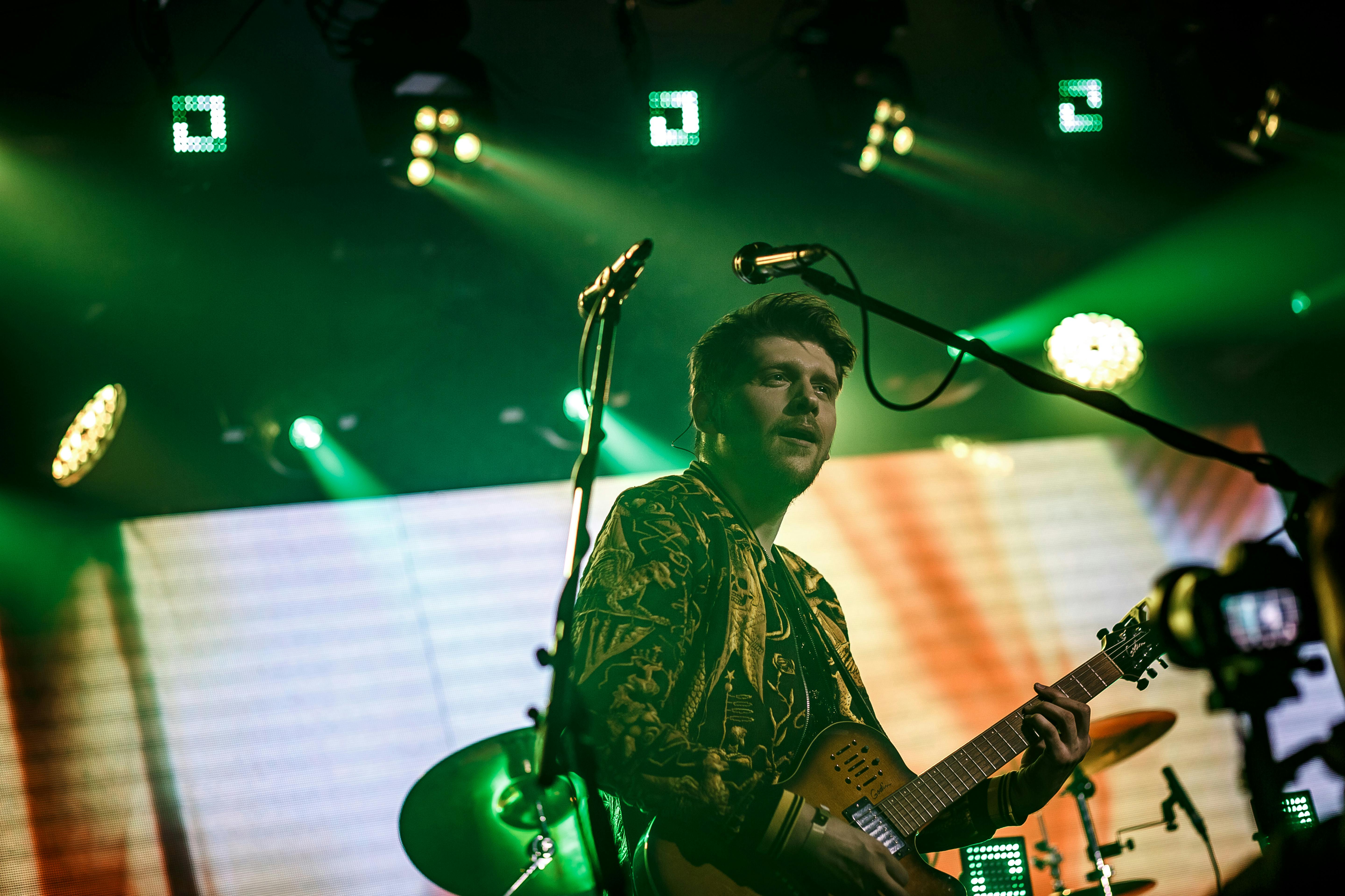 Hands holding zodiac wheel cards over a table with candles and notebook