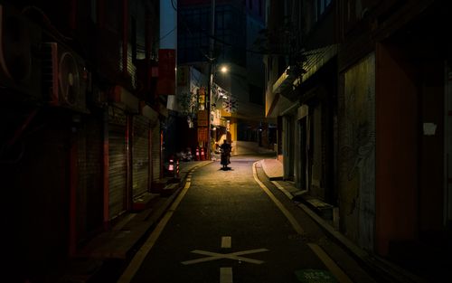 Free A lone person in an illuminated alley in Seoul, South Korea, capturing solitude and night ambiance. Stock Photo