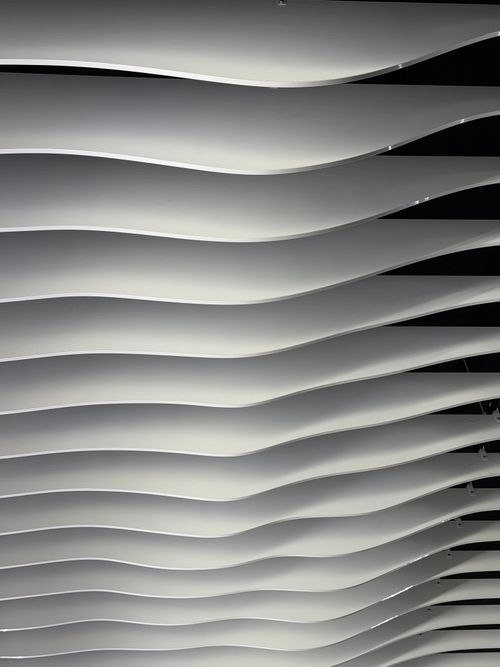 Free Abstract view of a modern architectural ceiling with wavy lines creating a dynamic pattern. Stock Photo