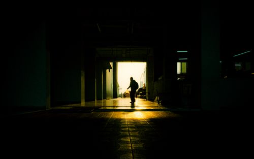 Free A skateboarder captured in silhouette, framed by light in an urban corridor. Stock Photo