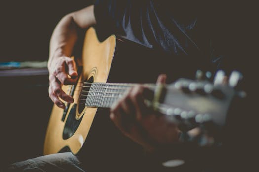 An intimate shot of a musician's hands skillfully playing an acoustic guitar.