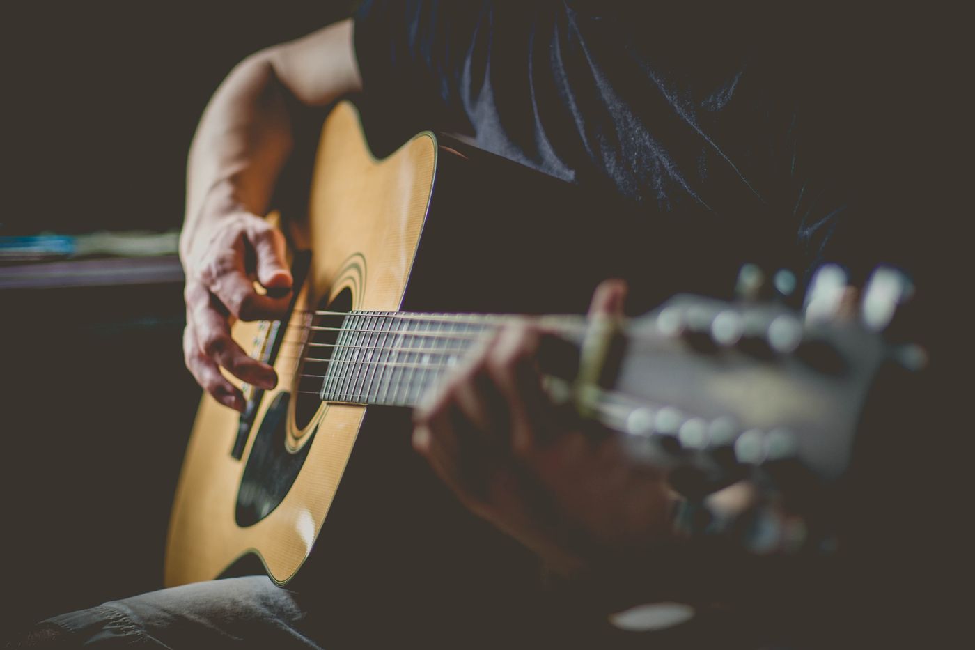 Close-up of a musician's hands playing an acoustic guitar
