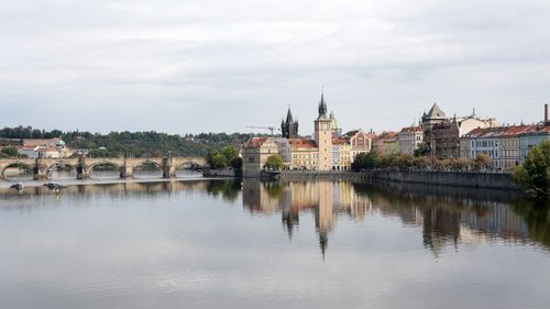 Free A serene panorama of Prague's historic waterfront, showcasing iconic architecture and Vltava River reflections. Stock Photo