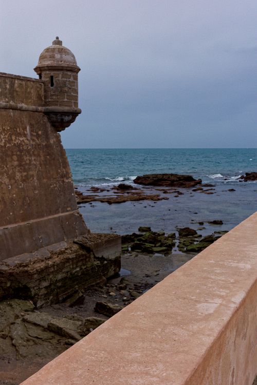 Free Sea view with ancient fortress tower and rocky coastline under a gray sky. Stock Photo