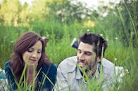 一对男女躺在草地上，在户外一起享受阳光灿烂的日子