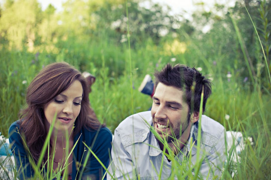 Man and Woman Lying on Grass Field