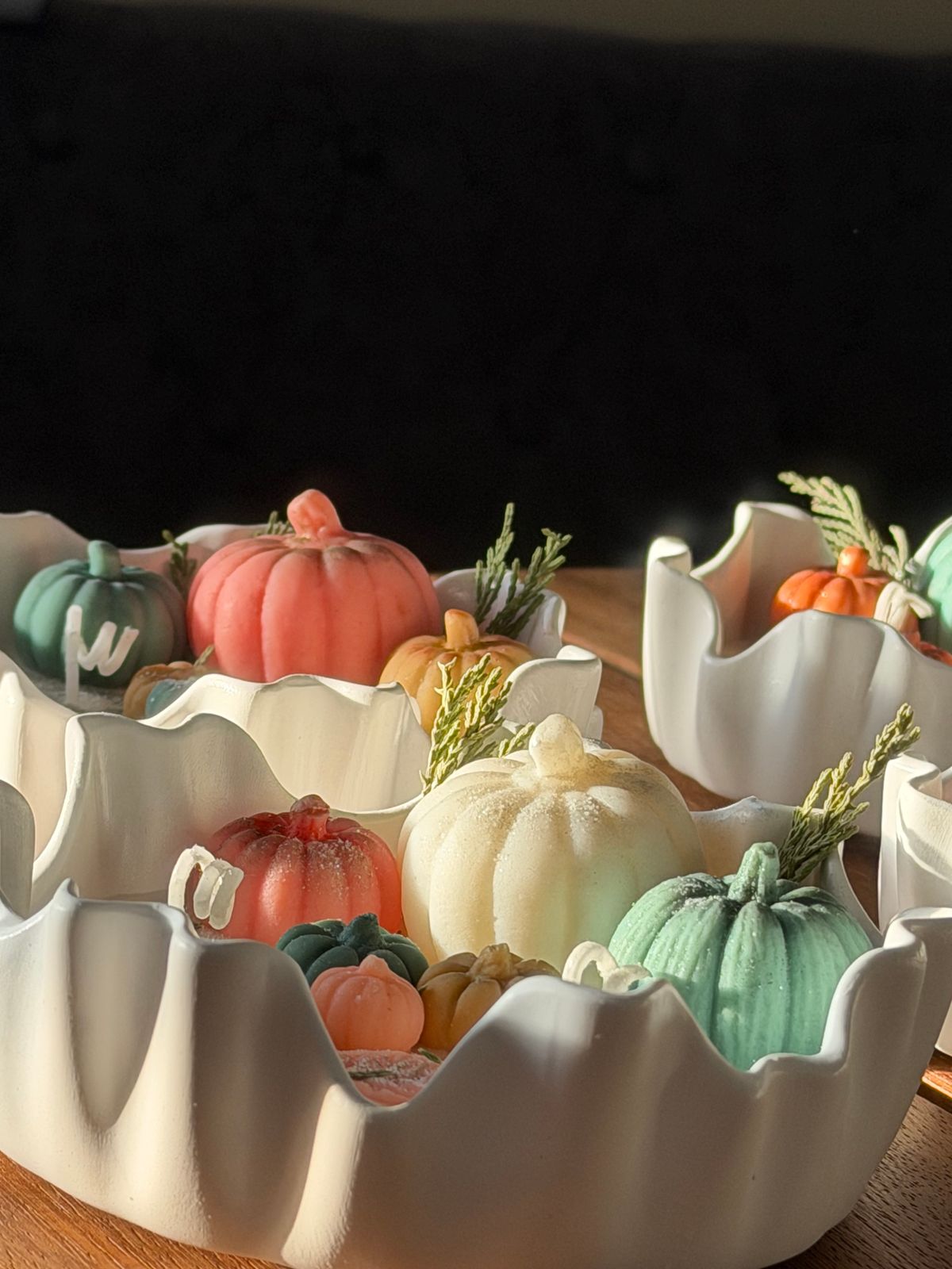 Arranged mini pumpkins in decorative ceramic bowls create a vibrant autumn centerpiece. Stock Photo.