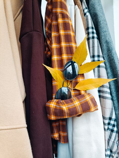 Free Stylish autumn clothing and accessories, featuring sunglasses and vibrant yellow leaves for a seasonal touch. Stock Photo