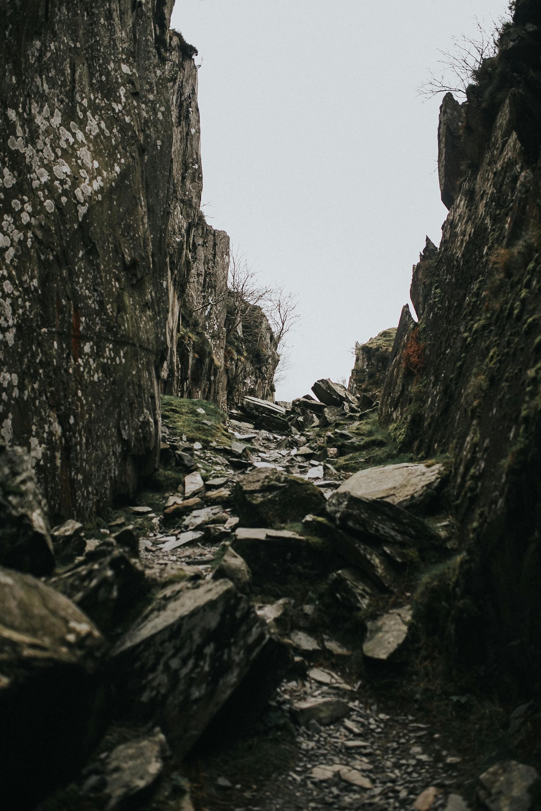 A rugged rocky pathway winding through a majestic mountain gorge, showcasing raw natural beauty.
