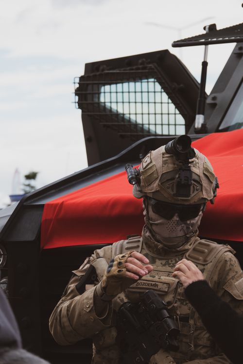 Free A soldier in tactical gear stands by an armored vehicle, ready for action. Stock Photo