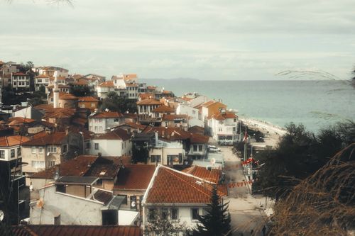 Free Picturesque view of a quaint coastal town with red-roofed houses by the sea. Stock Photo