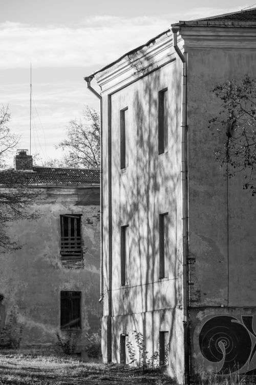 Free Black and white photograph of an abandoned urban building capturing shadows and textures. Stock Photo